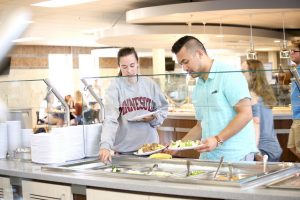 Students Claire Wass (left) and Nikko Aries (right) test out the salad bar at the newly renovated Jack Kane Dining Hall on main campus. (Photo by Kendahl Schlueter)