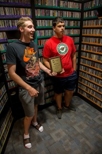 Seniors John Wojcik (left) and TJ Leverentz (right) hold an award KQAL received from Midwest Broadcast Journalists Association. The award was for first place in sports play-by-play in the student market radio category. (Photo by Taylor Nyman)