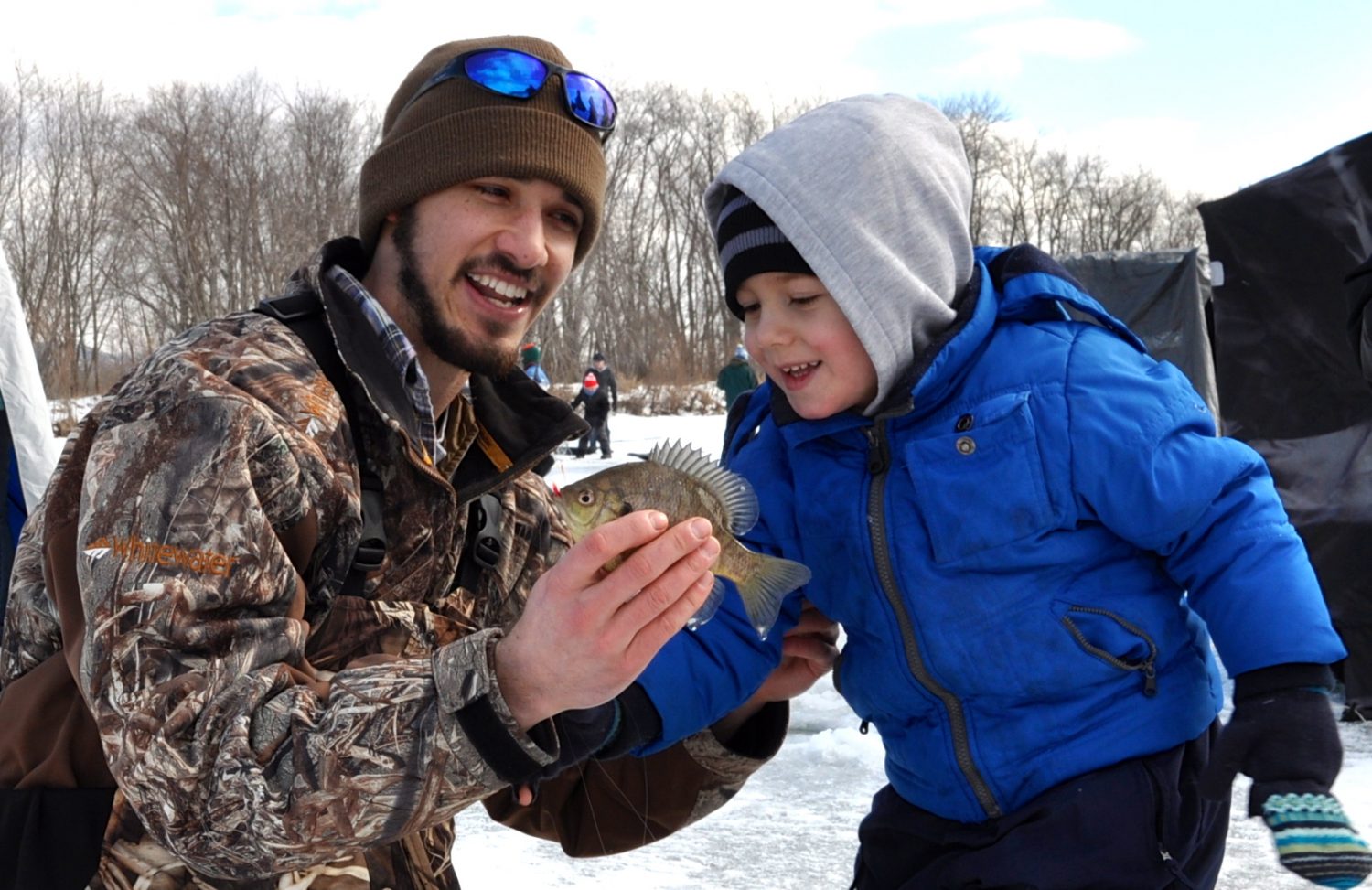 A volunteer gives a child a closer look at a fish caught during the ice fishing event.
Bartholome Rondet/Winonan