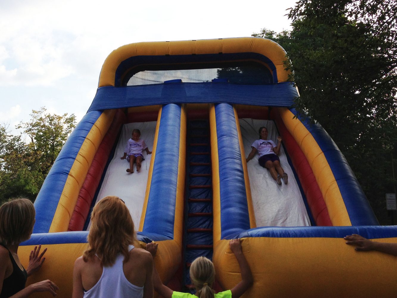 Warrior athletes and kids enjoy inflatable slides together.
JORDAN GERARD