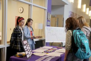 First-year students Grace Kaase (left) and Xena Tran (right) from Winona State Health and Wellness Advocates discuss stress with students at Health Hut’s “Tackling Mt. Stressmore” on Tuesday, Nov. 10. (Photo by Sara Tiradossi)