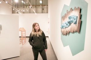Junior Alex Herman walks through the art exhibit in Watkins Art Gallery, “Medium Resolution,” by artist Jason Ramey, open until Feb. 3. (Photo by Sarah Murray)