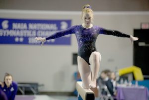 First-year Alyssa Carroll performs her beam routine at Winona State’s Brooke Baures “Smile On” Memorial Invite on Friday. (Photo by Jacob Striker)