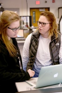 Junior Maddison Dodd (right) explains her computer malfunction to sophomore tech support employee Kelly Brennan (left) in Tech Support in Somsen Hall. (Photo by Taylor Nyman)