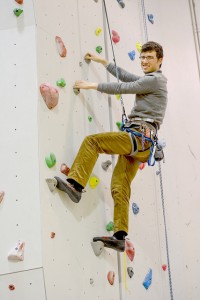Senior Avery Prondzinski climbs the rock wall at Wabasha Hall, where he works as a student manager of the outdoor education and recreation center. (Photo by Emma Masiulewicz)