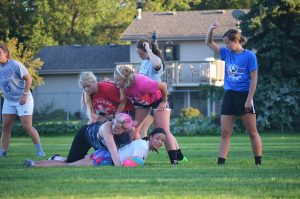 Gabby Calametti tackles Mya Johnson while their teammates stand in a defensive alignment during a Black Katt rugby practice at Minnesota State College - Southeast Technical. Middle row: Amy Scherer and Kelsey Skala. Back row: Lachen Esters , Rachel Hanning and Haylet Cederburg. (Photo by Nicole Girgen)