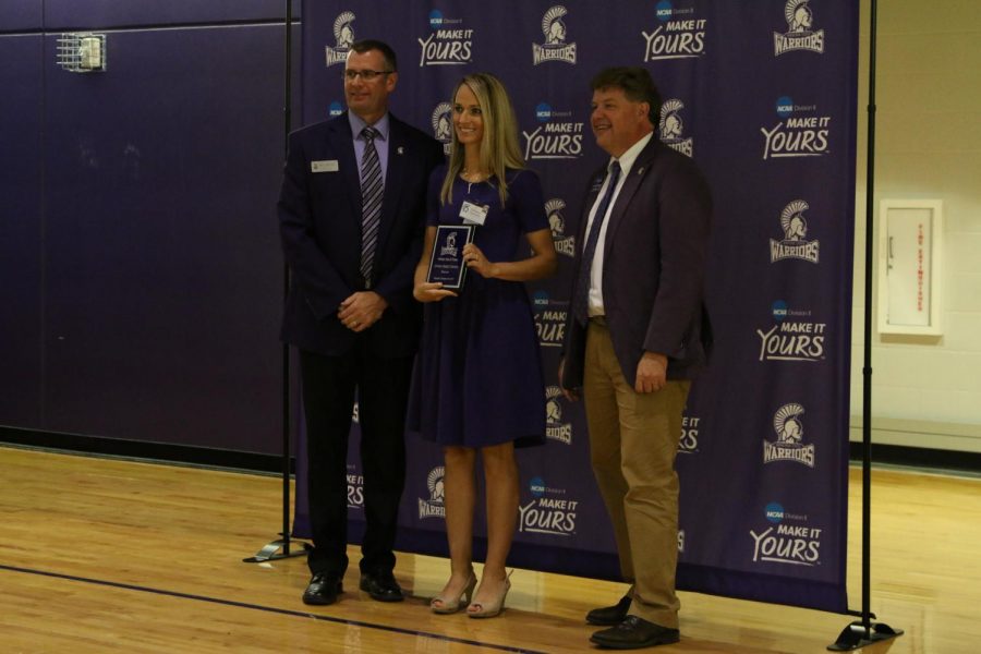 Emily (King) Callender, a former soccer player and the class of 2008, stands with the Athletic Director, Eric Schoh, and President Scott Olson as she is inducted into the Winona State Hall of Fame.