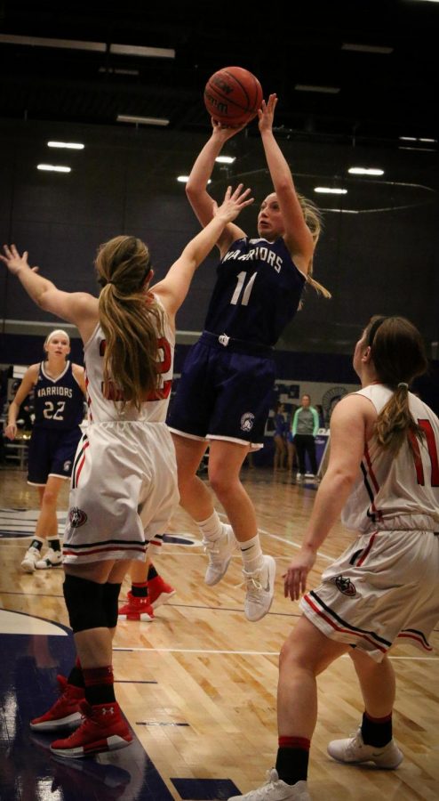 First year center Emily Kieck scores a jumpshot over St. Cloud defendent, Amanda Christianson, during Saturday night’s game in McCowan Gymnasium. The Warriors lost to the Huskies 55-62.
