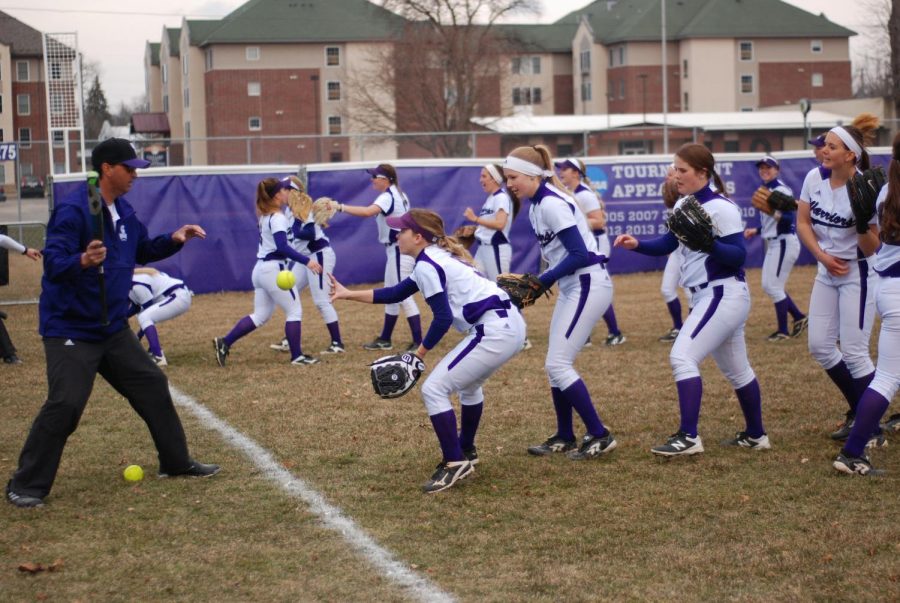 The Winona State Women’s Softball Team warm up before a game against St. Cloud State University on Friday, April 12. The Warriors played a double header against the Huskies, loosing their first game 1-3 and coming back with a 3-2 win. 