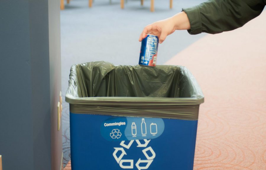 A student using one of the many recycling bins on campus. According to Nathan Engstrom, Director of sustainability at Winona State University, by spring semester they wish to use a different style of signage for the new containers.