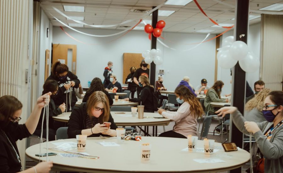 Masked students sit and create DIY keychains at Kryzsko Commons, on Friday, Oct. 2. Students must now adapt to mask ordinances and social distancing guidelines while engaging in on-campus activities.
