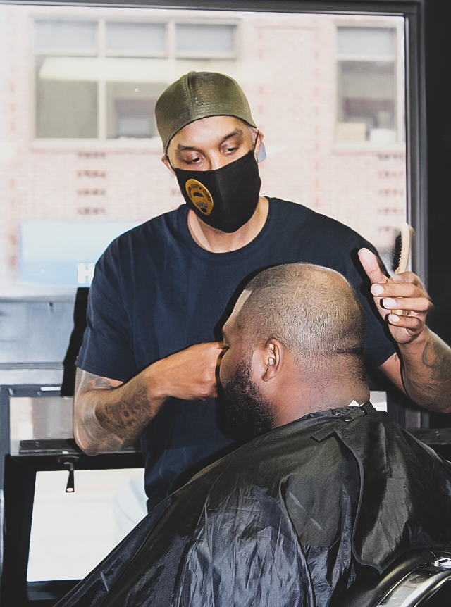 Gilbert Jordan IV, or more commonly known as Uncle Gil giving a  haircut to Kevin Suber in his newly opened barbershop, called Uncle Gils Cutz, located located in the Kensington building in Winona, Minn.