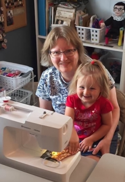 Jackie Larson with her granddaughter making a mask in their sewing machine. Larson has been making free masks for the community since the beginning of the pandemic.