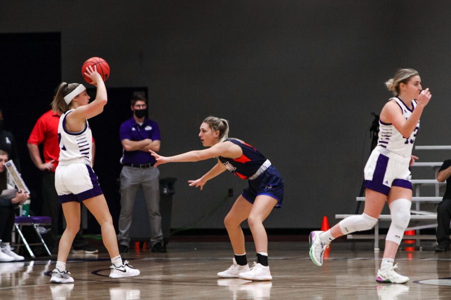 Winona+State%E2%80%99s+Emily+Kieck+%2811%29+shooting+the+ball+from+the+three-+point+line+while+blocked+by+UMa-+ry+athlete.+Emma+Fee+%2843%29+is+also+pictured+running+across+the+shot.+In+the+first+half+of+the+game%2C+Sec-+ond+year+Caitlyn+Riley+%280%29+start-+ed+the+game+with+a+three-point+attempt+only+12+seconds+into+the+game.+Shortly+to+follow%2C+Kieck+had+two+free+throws+and+a+triple+of+her+own.+To+end+the+first+half%2C+Riley+scored+another+three-point-+er+to+bring+Winona+State+to+39-35+at+halftime.