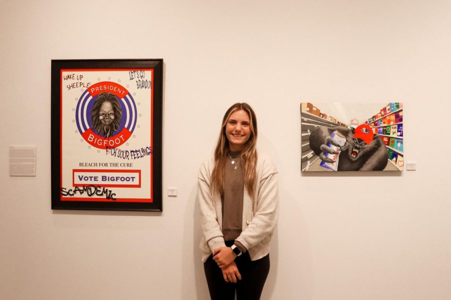 Fourth-year Lauren Mahnke with her work on display in Watkins Hall. The senior art pieces will continue to be on display daily from April 25 until May 6, 10 a.m. to 3 p.m. Monday through Saturday.
