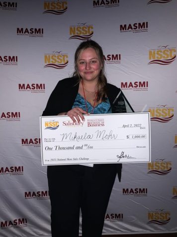 Mikaela Mohr, a member of Winona State Universitys Sales Team, pictured with a $1,000 check after taking first place in the Sales Challenge at the teams last competition.