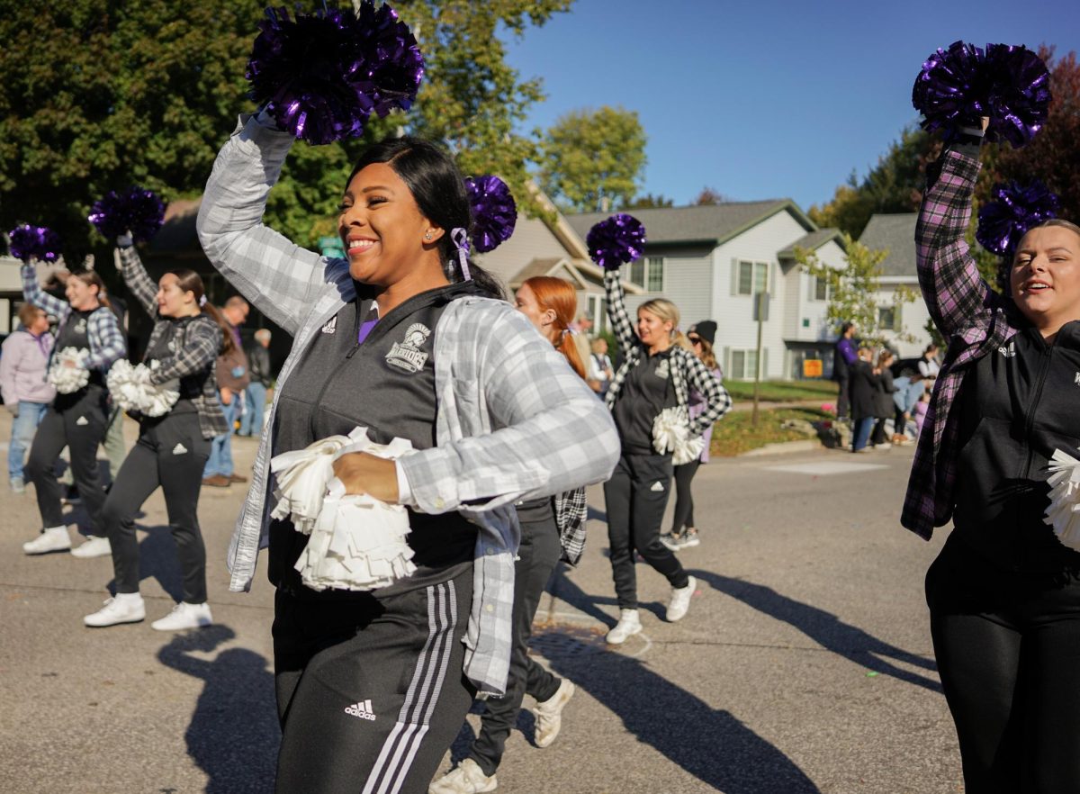 The WSU Cheer Team passes through Huff Street, hyping up the crowd during the Homecoming Parade.