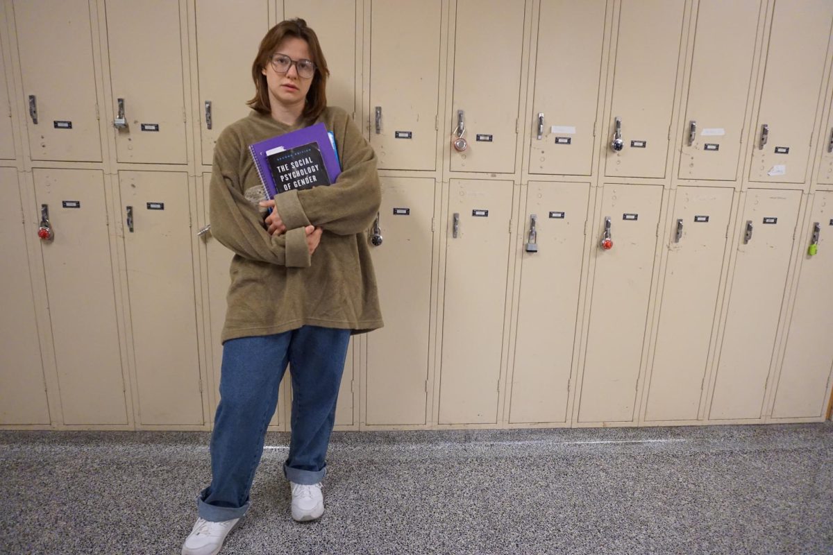 Student holding textbooks including ‘The Social Psychology of Gender’ at Watkins Hall on Winona State Campus. Traditional gender roles regarding gender have changed in recent years with college and views on college.