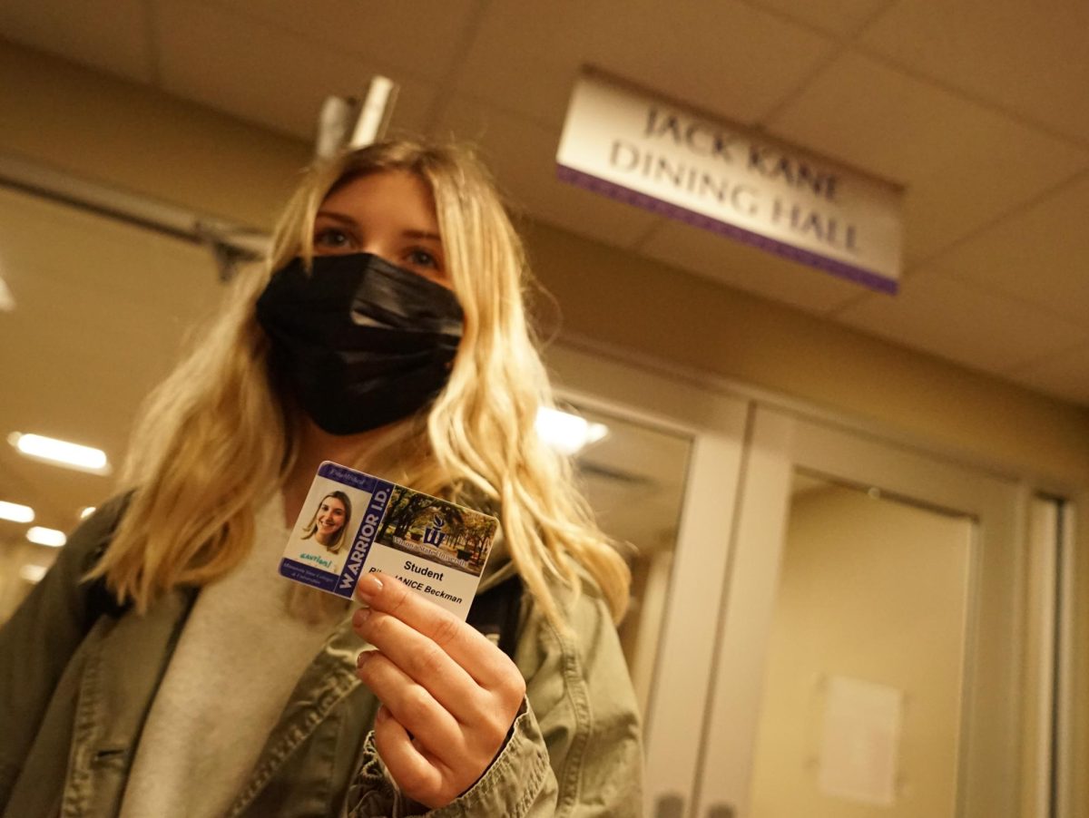 Winona State University Student poses for a photo, wearing a mask before safely accessing the dining
hall. 