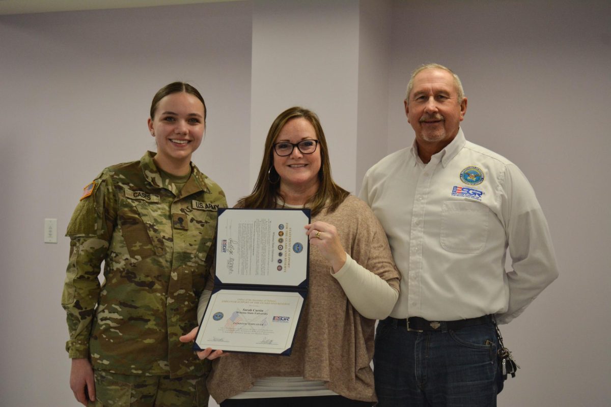 Smiling brightly and in uniform, second year student Rose Cases presents Sarah Curtin an award for Employer Support of the Guard and Reserve on Jan. 11, 2024.