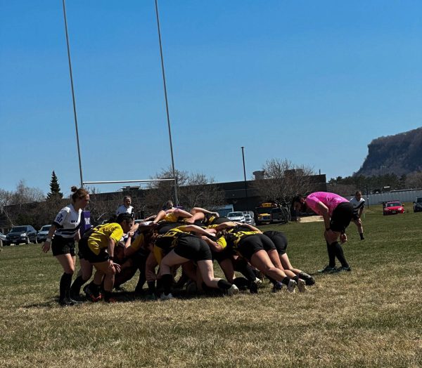 The Black Katts and Gustavus Alolphus women’s rugby club in a scrum.