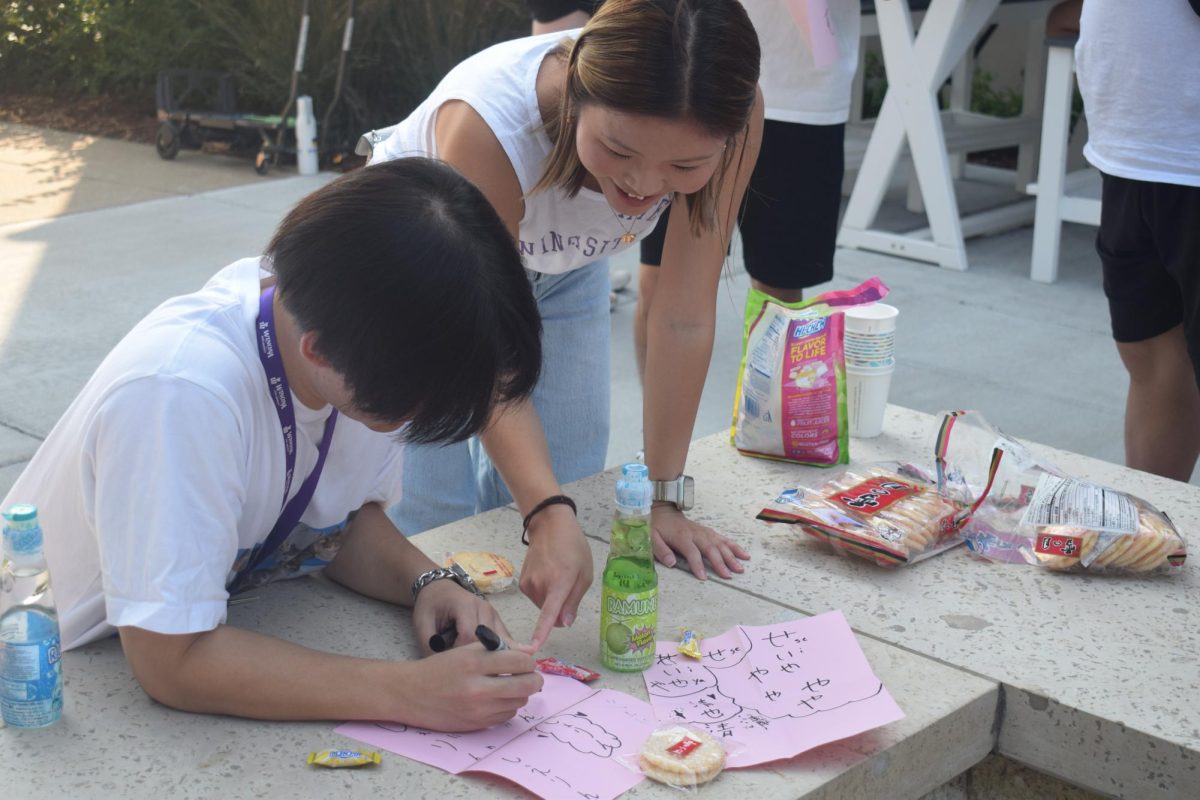 Students practiced writing their name in Japanese by the fire feature outside of Kryzsko Commons.