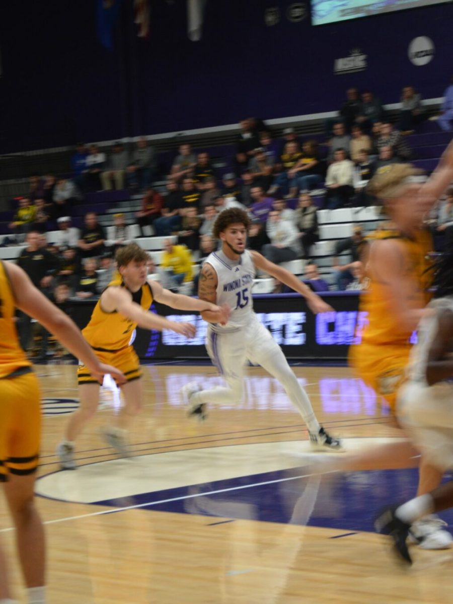 Warrior Isaiah Thompson makes his way towards the hoop, skillfully avoiding his opponents.