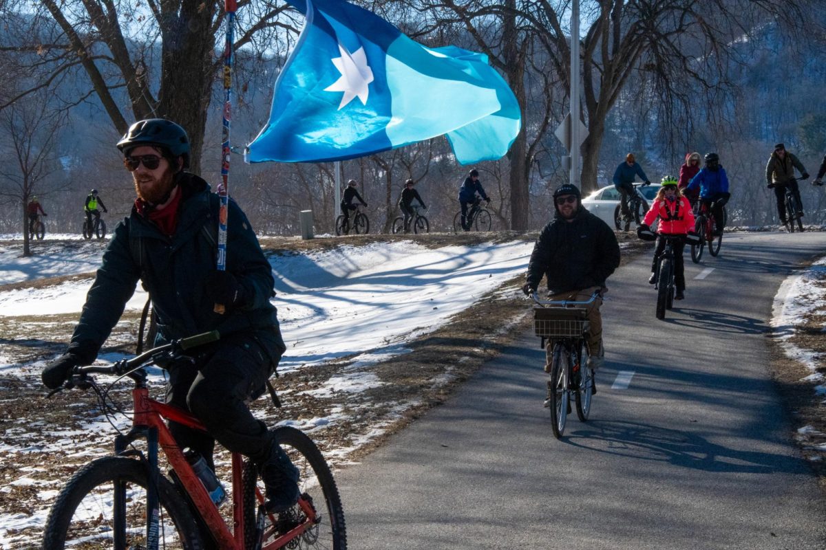 A cyclist proudly flies the Minnesota flag after attaching it to something they could hold while riding. On Saturday Jan 31, cyclists rode together honoring Alex Pretti who had been shot at according to the New York Times “10 times in less than five seconds” by ICE on Jan 24.