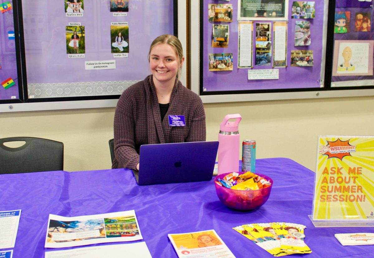 Abby Raichert set up at her booth to inform students more about summer options at Winona State University. 