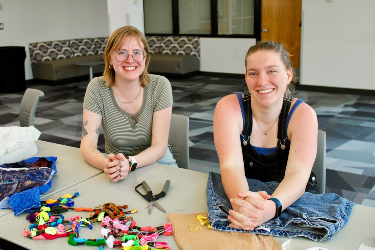 Rachel Fredrick (left) and Marcie Peettys (right) host an event for environmental club to show students how to upcycle their clothes. 